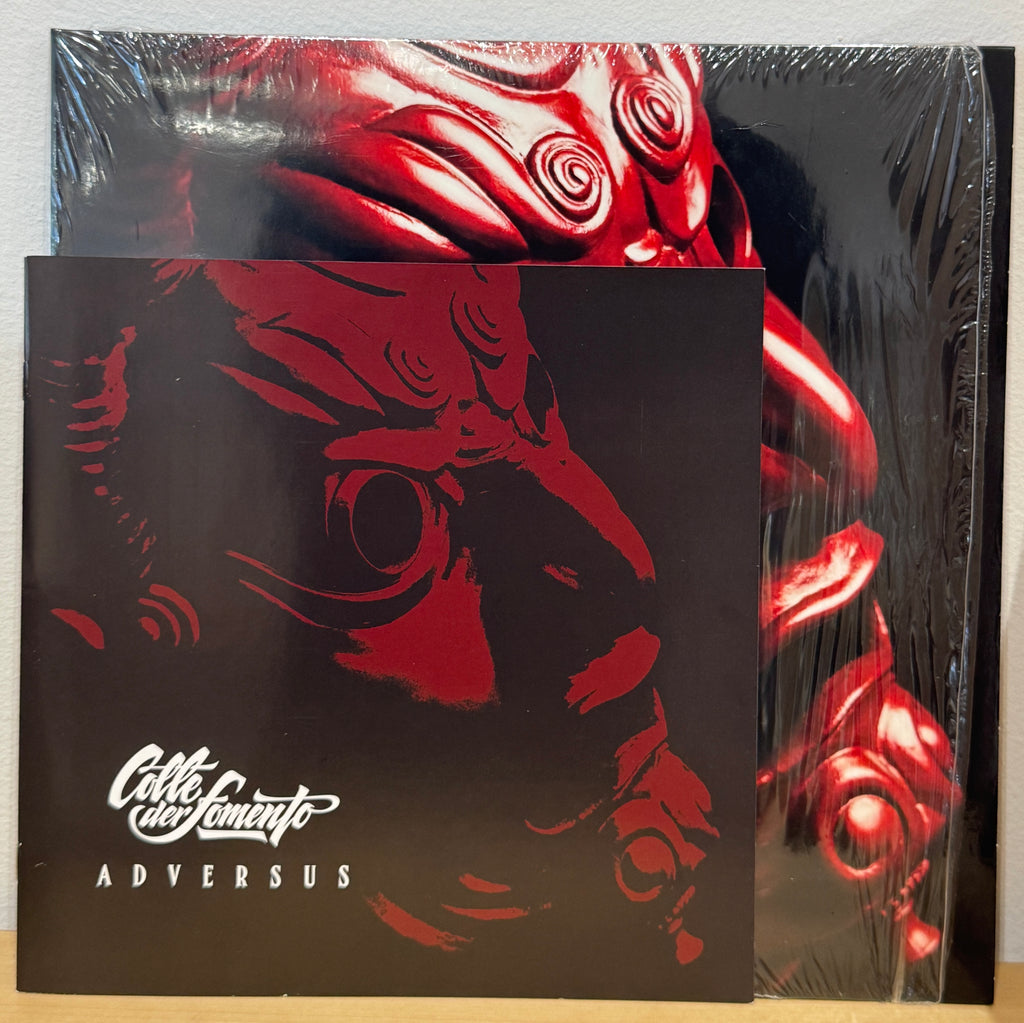 Booklet di Adversus dei Colle der Fomento con grafica nera e rosso scuro