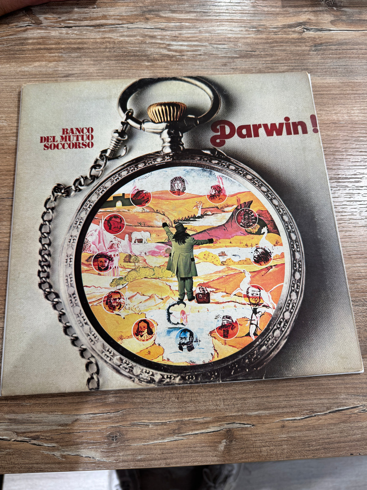 Fronte della copia di Darwin! del Banco del Mutuo Soccorso con grafica di un orologio da taschino