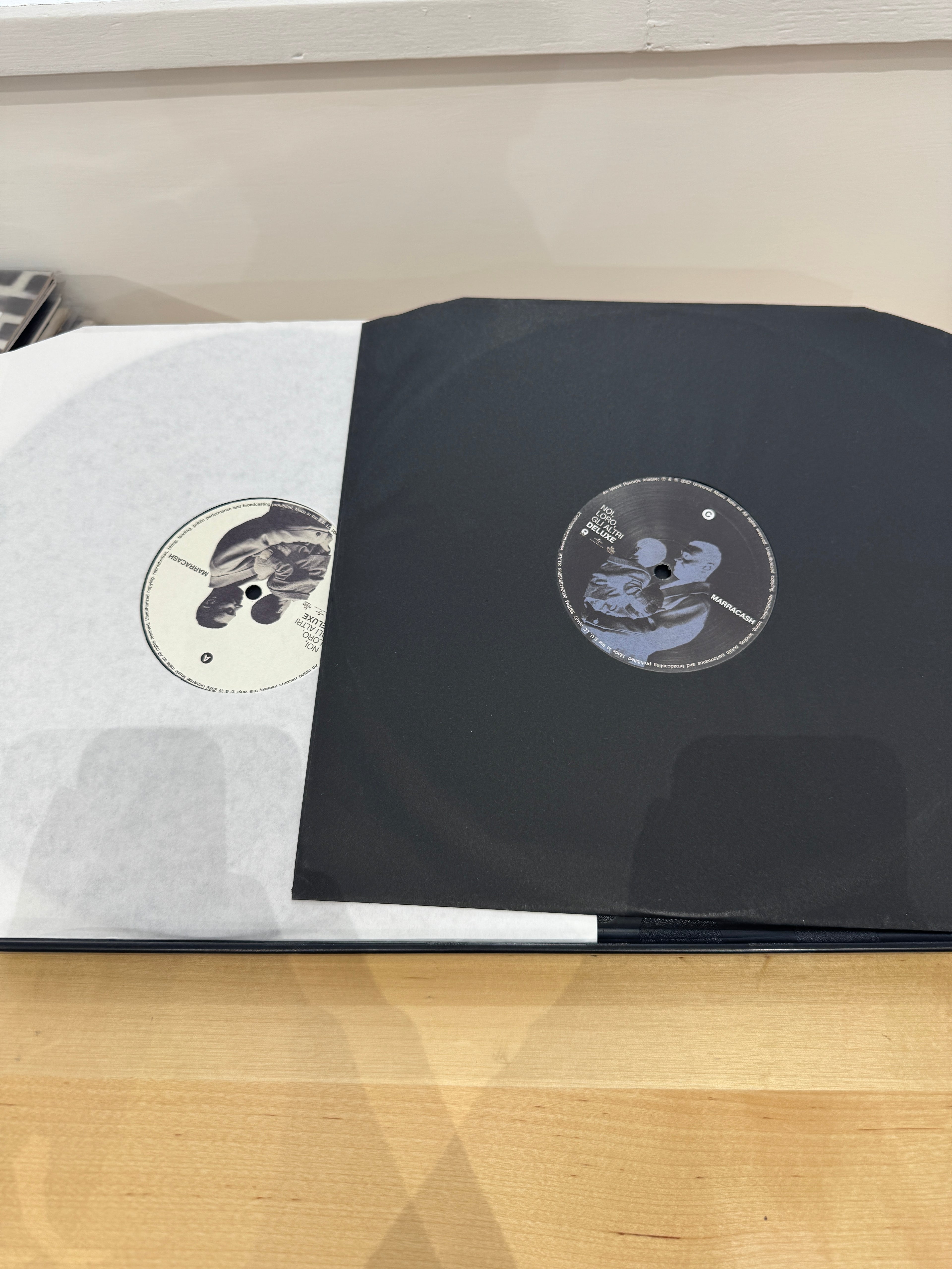 Doppio vinile Marracash Noi Loro Gli Altri Deluxe aperto - due dischi neri con etichette in bianco e nero con artwork fotografico, inner sleeve neri
