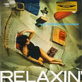 Copertina Miles Davis Relaxin with the Miles Davis Quintet SAAR - donna sdraiata su amaca vista dall'alto, scritta Relaxin in bianco in basso, sticker dorato Original Mono Recording in alto a destra, catalogo LPM 2059